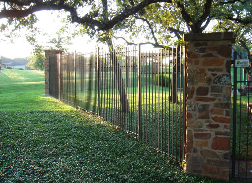 staggered 3 rail metal fence with stone pillars