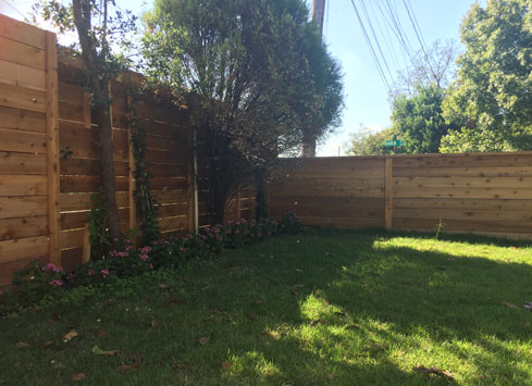 very tall backyard fence with horizontal boards stained